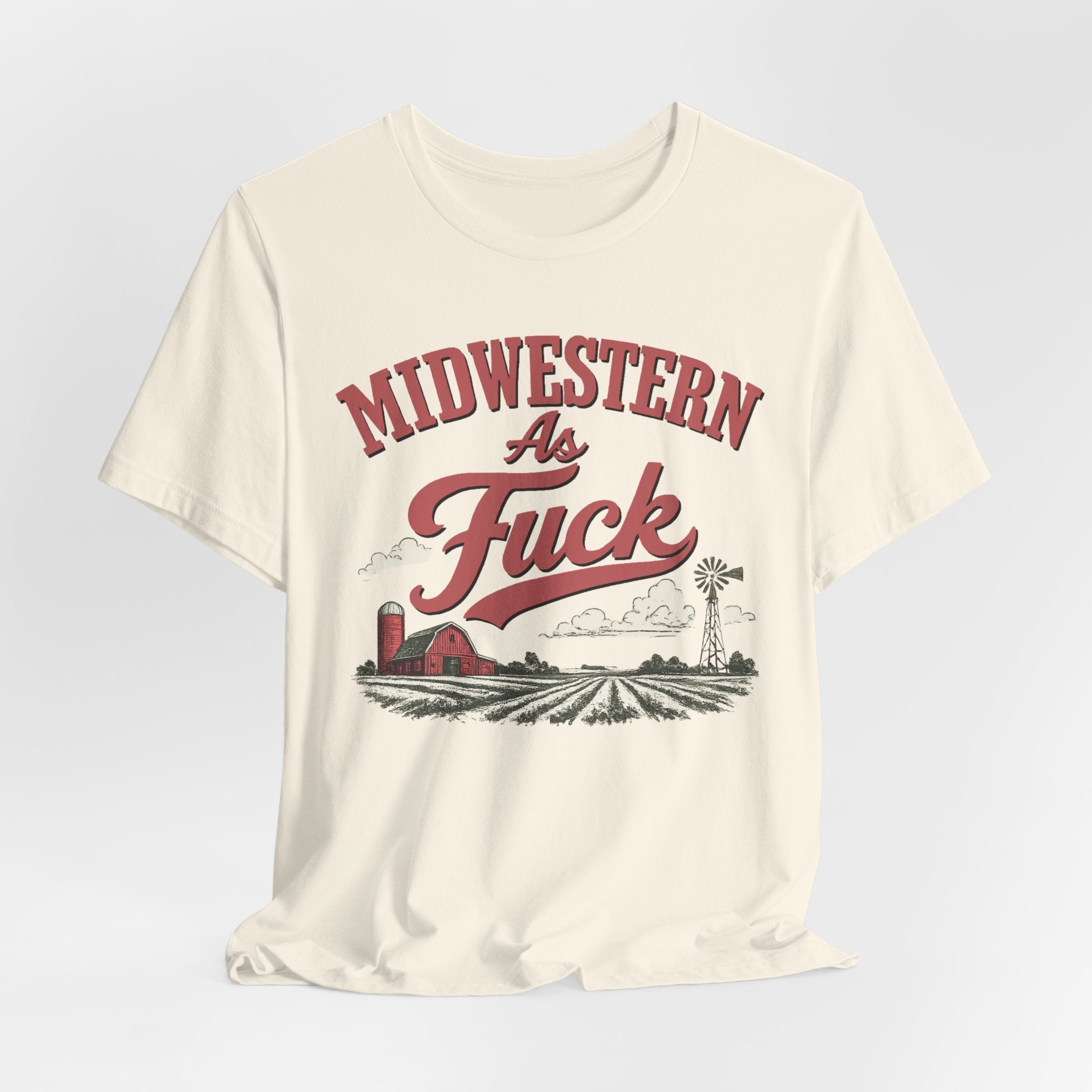 Natural colored Midwestern As Fuck t-shirt laid flat with the hem gathered, showing the red barn and windmill graphic.