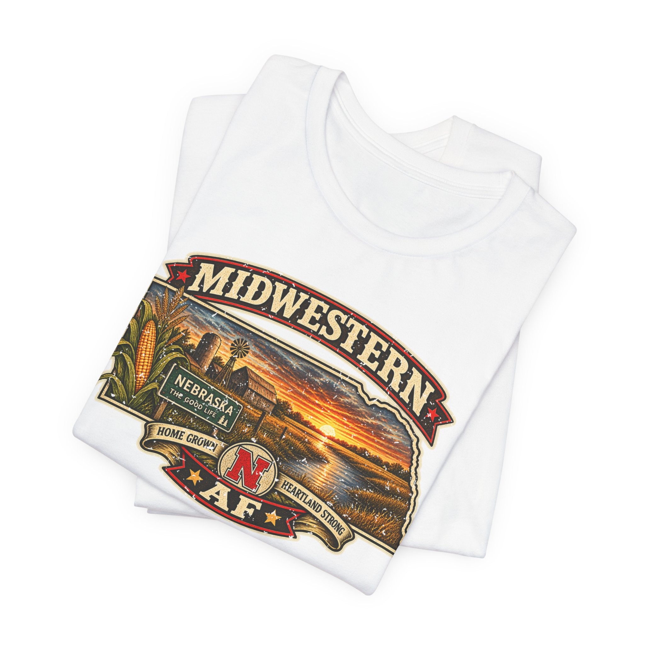 Folded white Nebraska tee with the corn, barn and prairie sunset artwork in close detail