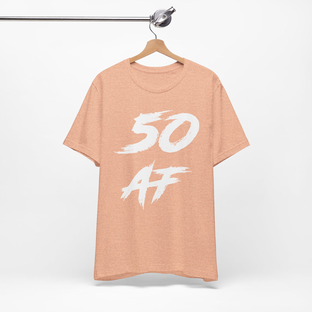 Heather Peach birthday t-shirt on a wooden hanger showing the white 50 AF print