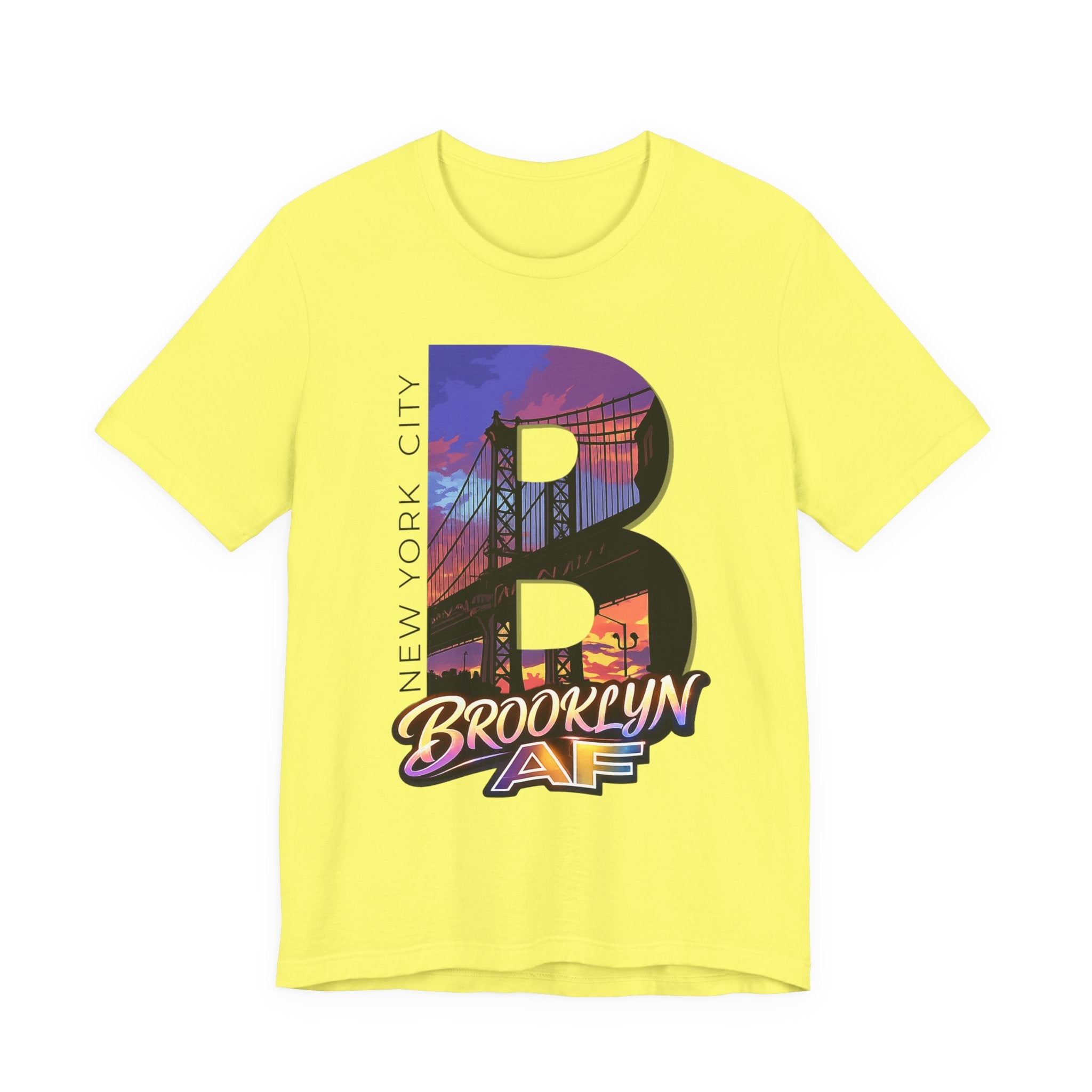 Bright yellow t-shirt, flat lay, with a bold oversized "B" featuring a Brooklyn Bridge sunset skyline graphic.