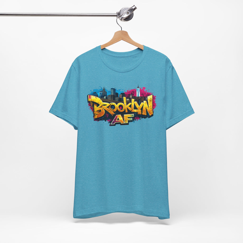 Heather Aqua t-shirt on a wooden hanger, front view, with graffiti-style Brooklyn AF lettering over a skyline splash.