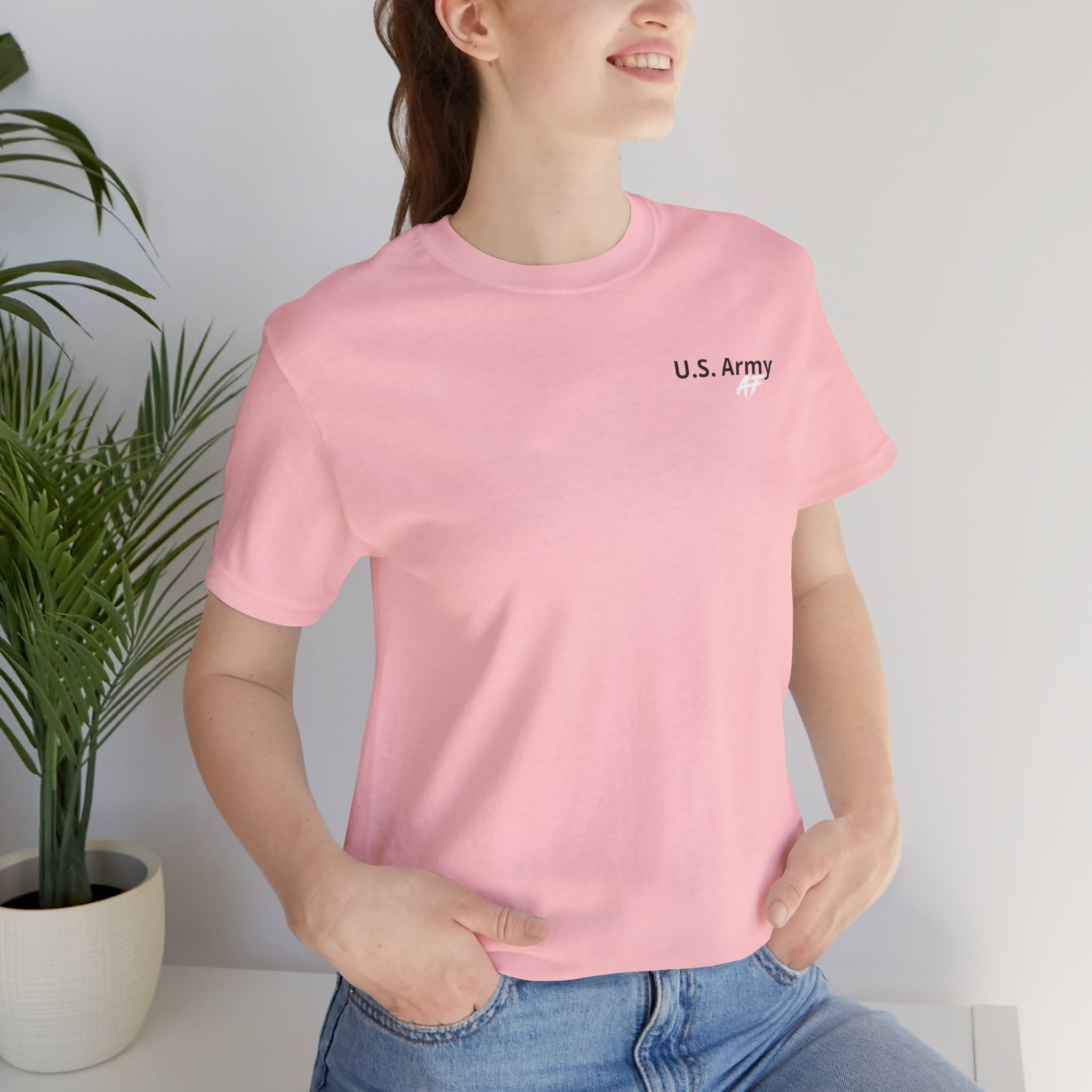 Woman wearing the Army veteran T-shirt in Pink beside a potted plant