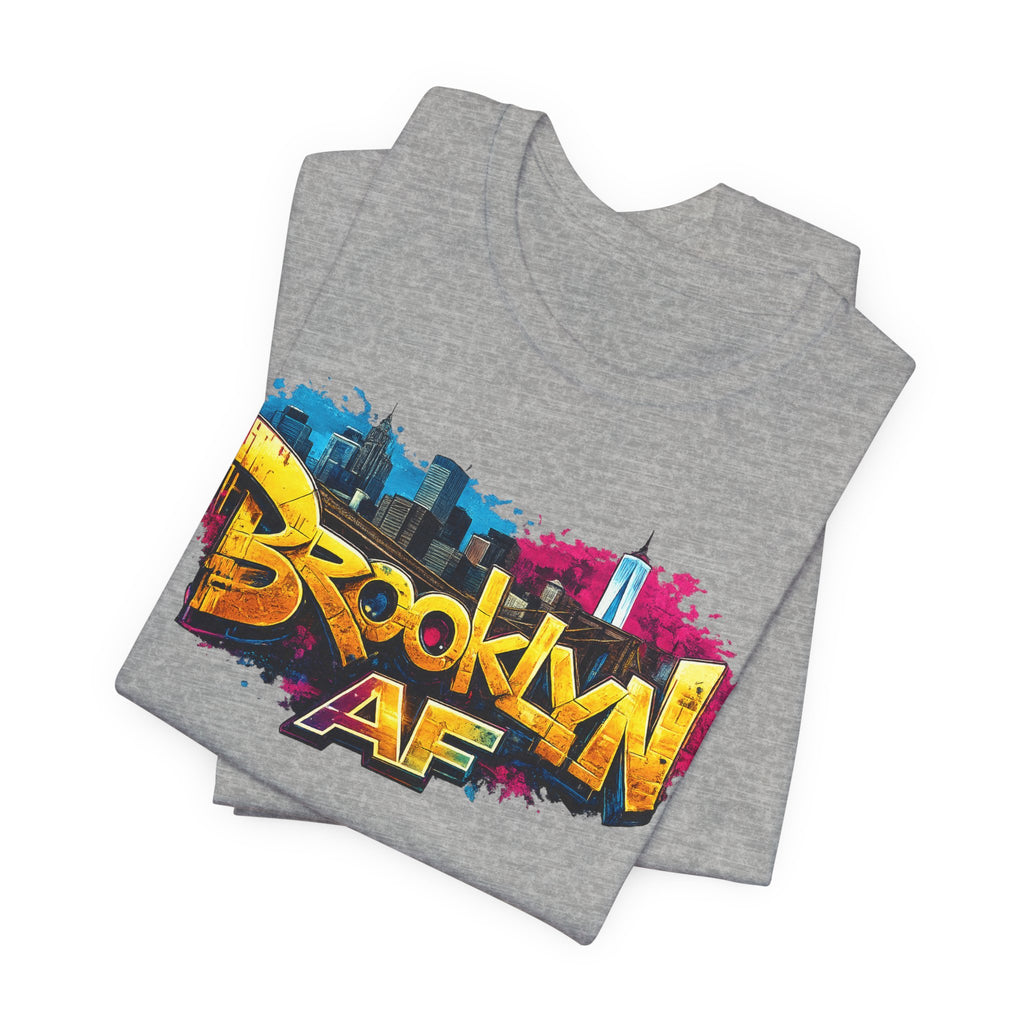 Athletic Heather t-shirts folded in a stack, showing graffiti Brooklyn AF lettering over a skyline paint splash.