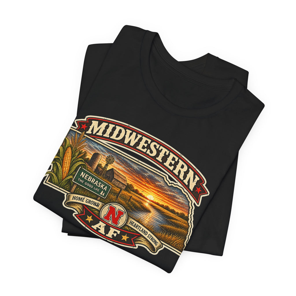 Folded black Nebraska tee, close on the Home Grown and Heartland Strong detail beside the red N
