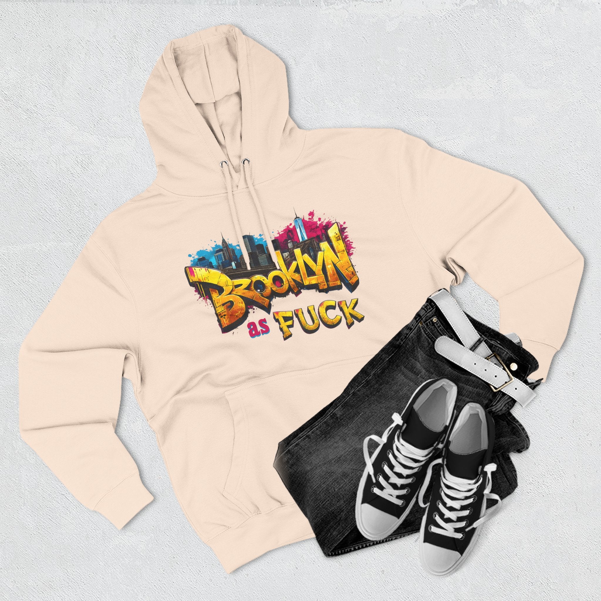 Oatmeal heather hoodie styled flat lay with jeans, belt, and sneakers, graffiti Brooklyn As Fuck NYC skyline print.