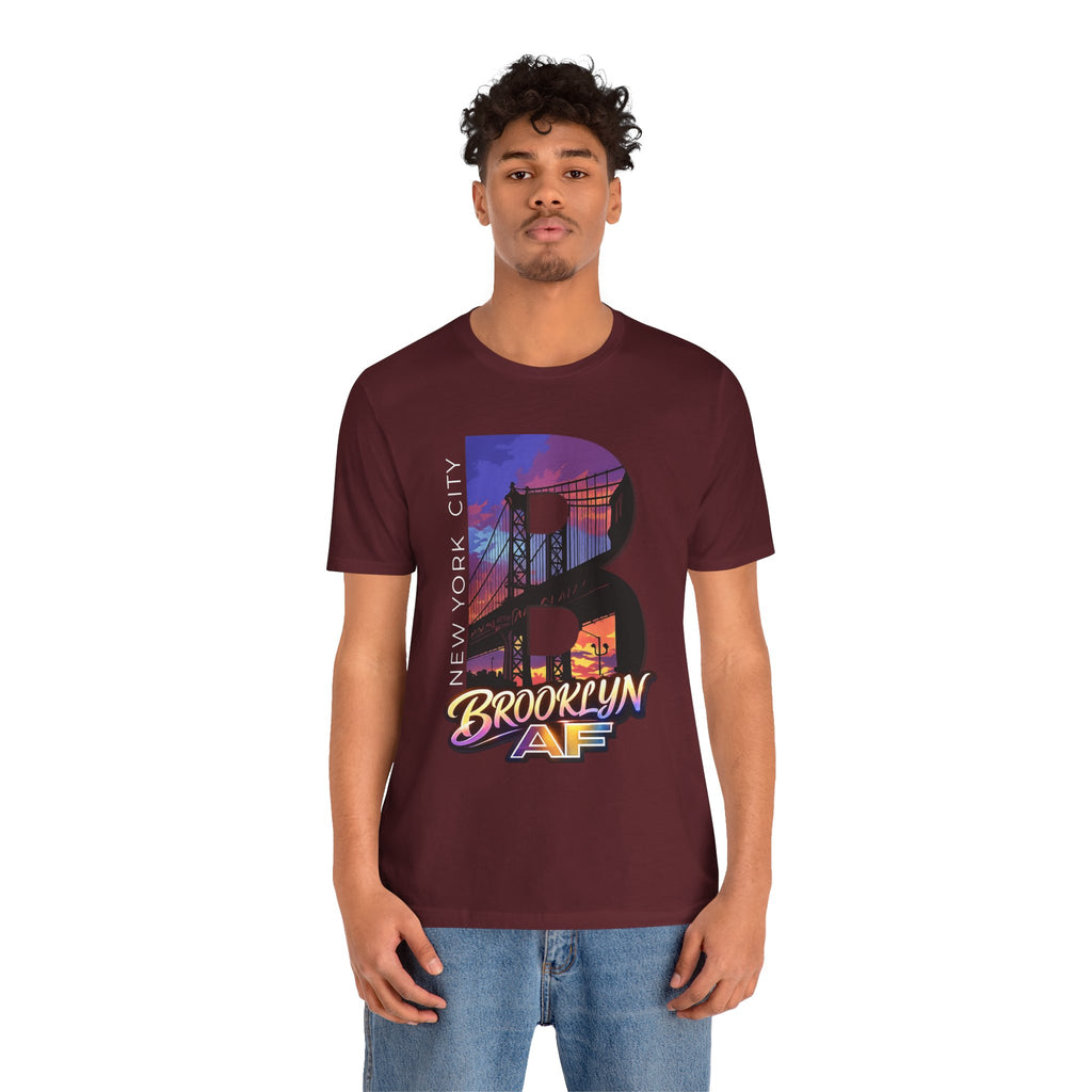 Maroon t-shirt worn by a model, front view showing the full 'B' Brooklyn Bridge sunset skyline graphic and logo
