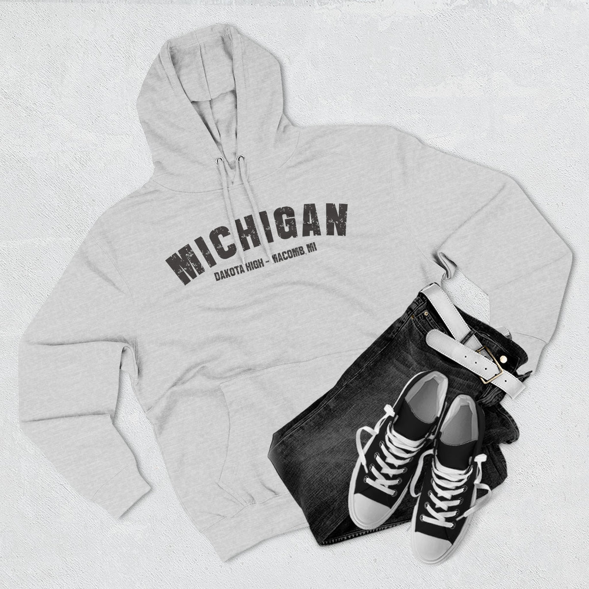 Heather grey Michigan hoodie styled flat with denim and trainers, varsity MICHIGAN over a school line