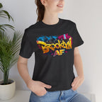 Dark Grey Heather t-shirt worn by a model, close-up of chest print showing graffiti Brooklyn AF lettering and skyline.