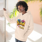 Oatmeal heather hoodie worn by a female model near a wire fence, front view, graffiti Brooklyn As Fuck NYC skyline print.