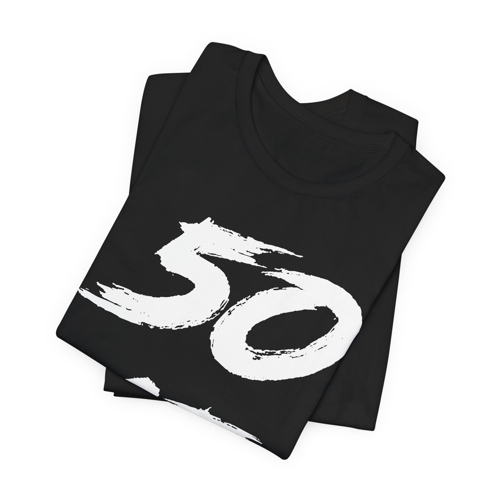 Folded black birthday tees stacked, the white 50 filling the top fold