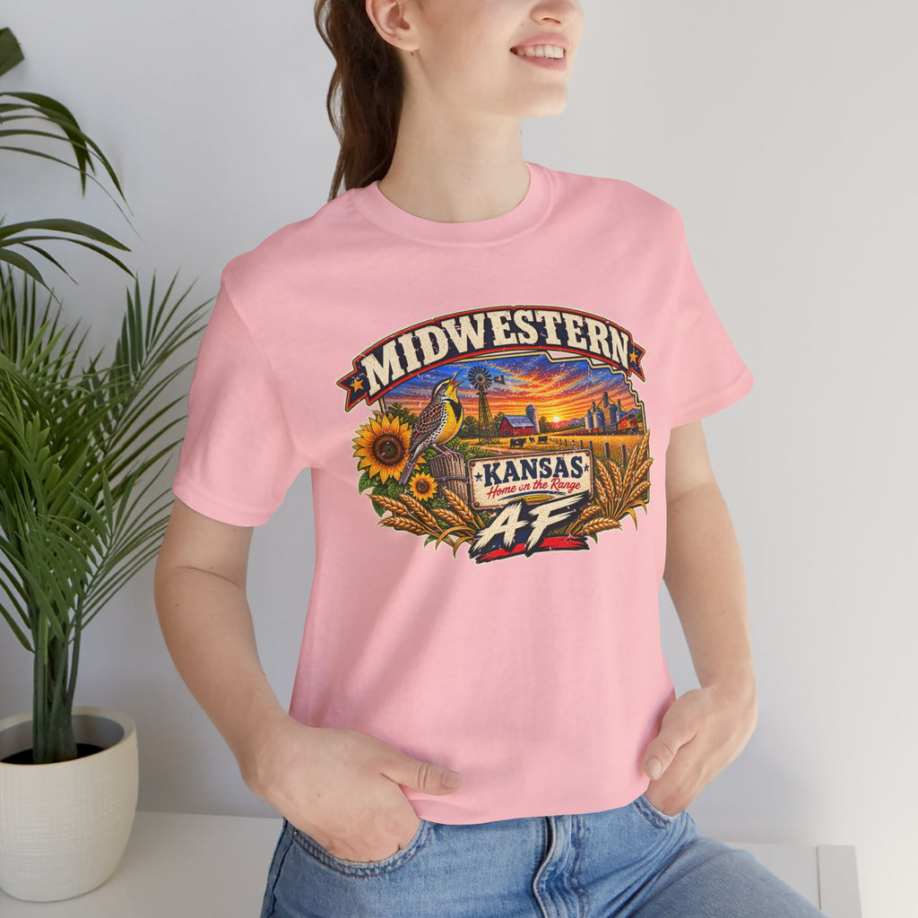 Close crop of the pink Kansas AF tee worn indoors beside a plant