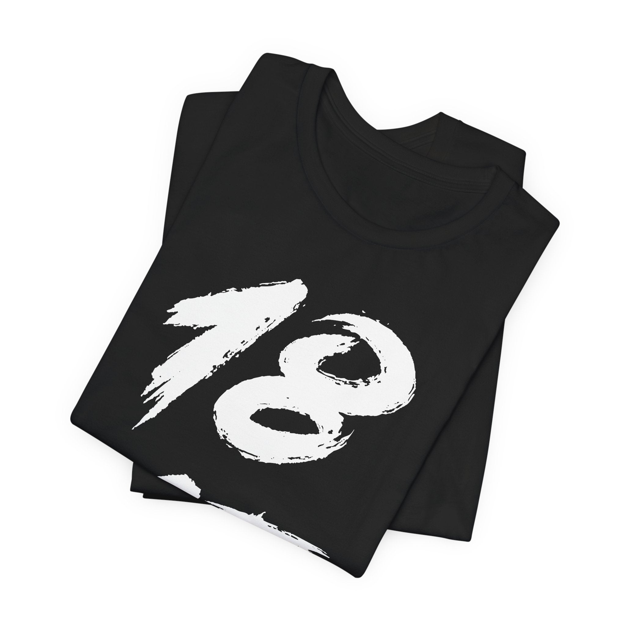 Folded black birthday tees stacked, the white 18 filling the top fold