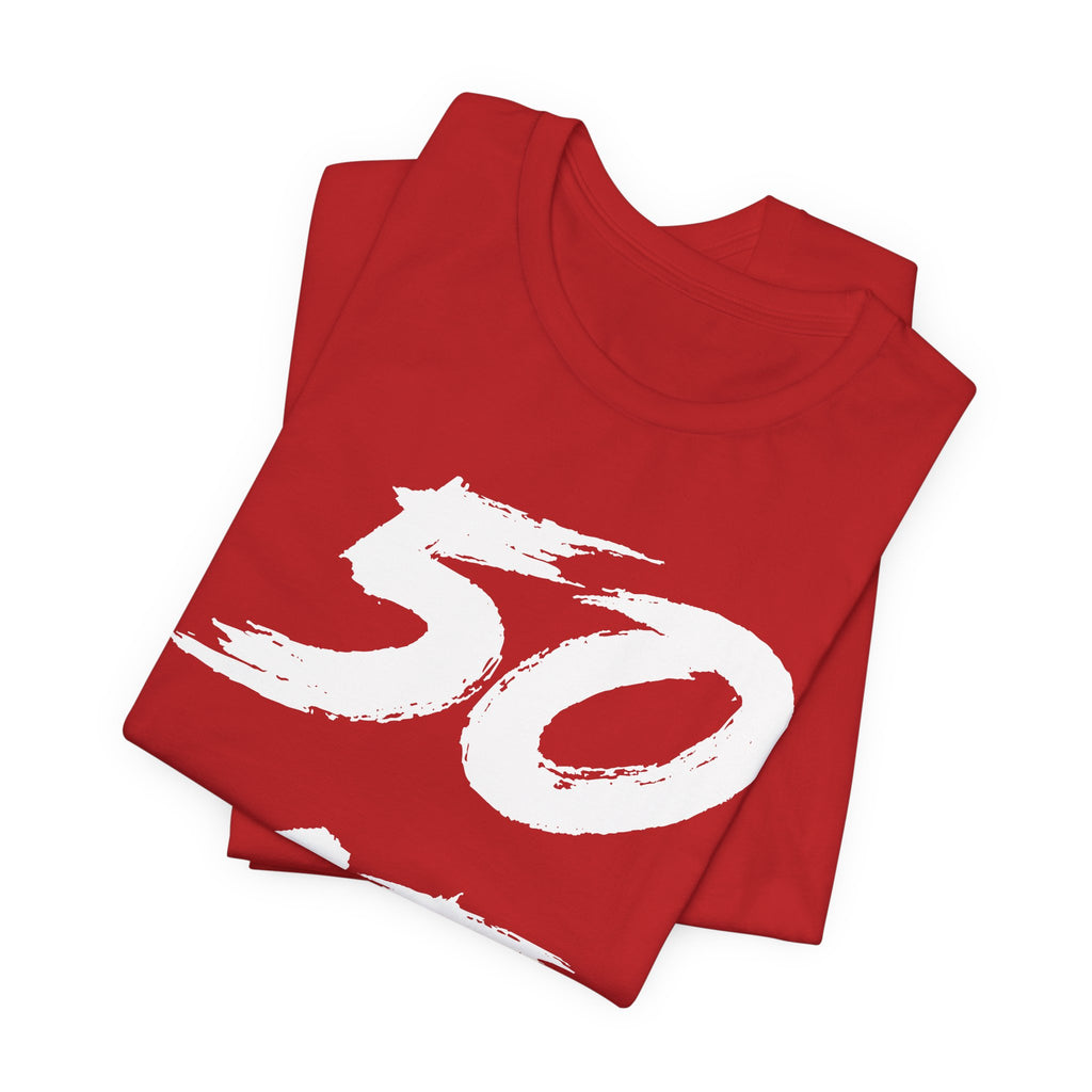 Folded red birthday tees stacked with the white 50 across the top fold