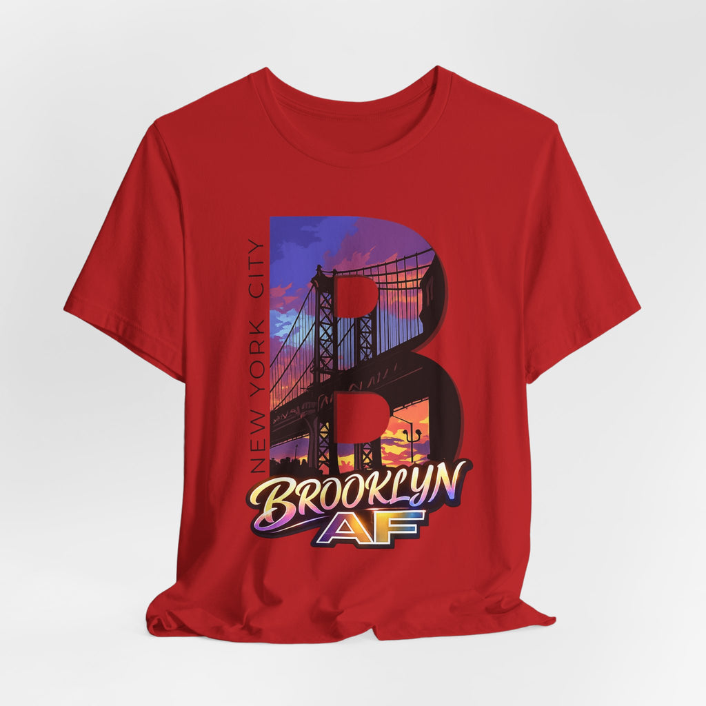 Red tee, flat lay, front view, featuring the oversized "B" Brooklyn Bridge sunset skyline graphic and logo.