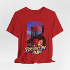 Red tee, flat lay, front view, featuring the oversized "B" Brooklyn Bridge sunset skyline graphic and logo.