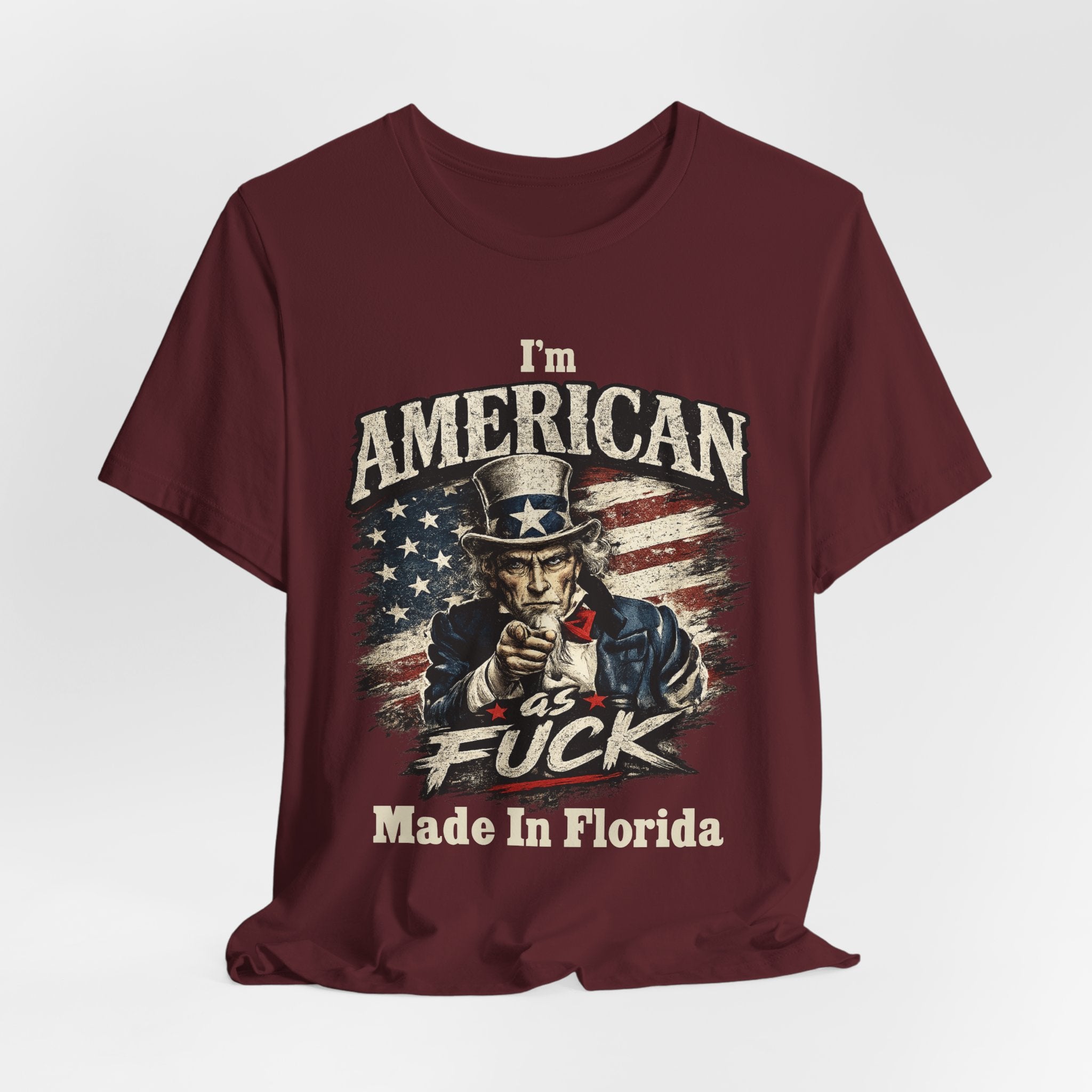 Maroon t-shirt laid flat with soft wrinkles, featuring the vintage Uncle Sam patriotic design