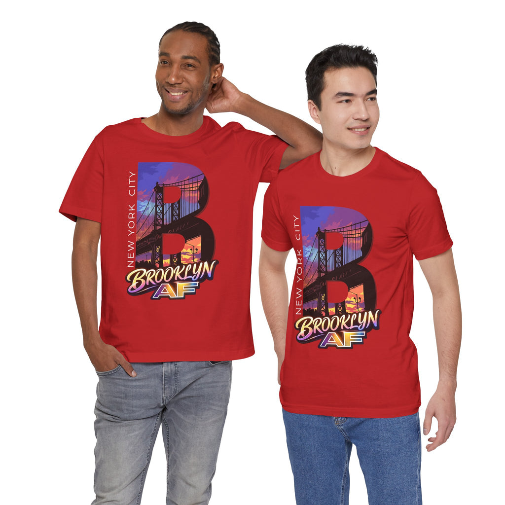 Two models wearing red t-shirts, front view, both featuring the 'B' Brooklyn Bridge sunset skyline graphic