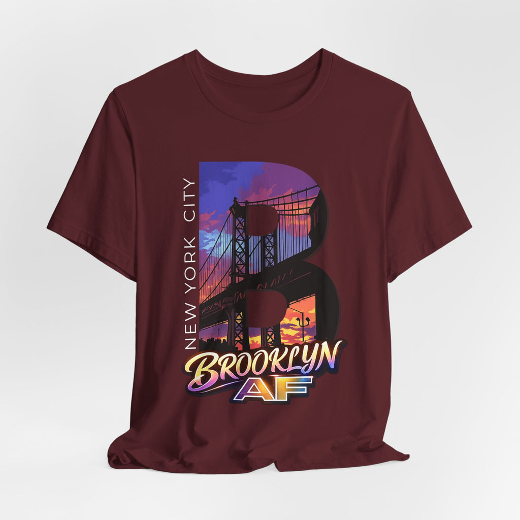 Maroon t-shirt flat lay, front view with full 'B' graphic, Brooklyn Bridge sunset skyline and 'Brooklyn AF' logo