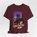 Maroon t-shirt flat lay, front view with full 'B' graphic, Brooklyn Bridge sunset skyline and 'Brooklyn AF' logo