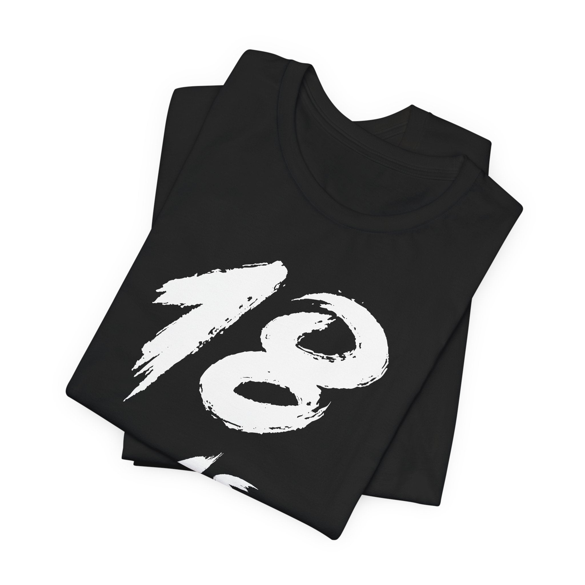 Folded black birthday tees stacked, the white 18 filling the top fold