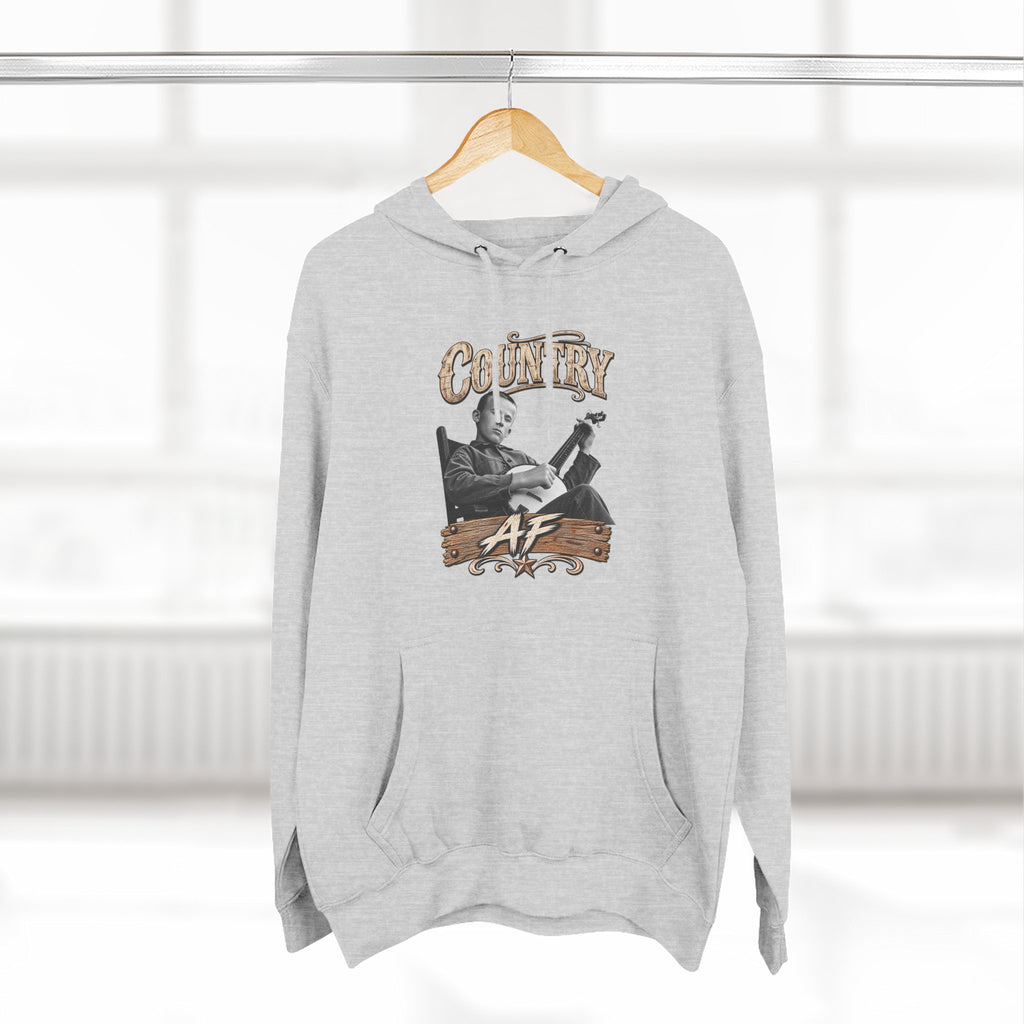 Heather Grey Country AF hoodie hanging on a wooden hanger by a window