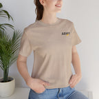 Woman wearing the Army veteran T-shirt in Tan beside a potted plant