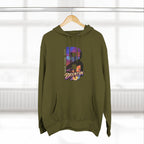 Army green hoodie on a wooden hanger against a blurred window, showing the oversized "B" skyline graphic.