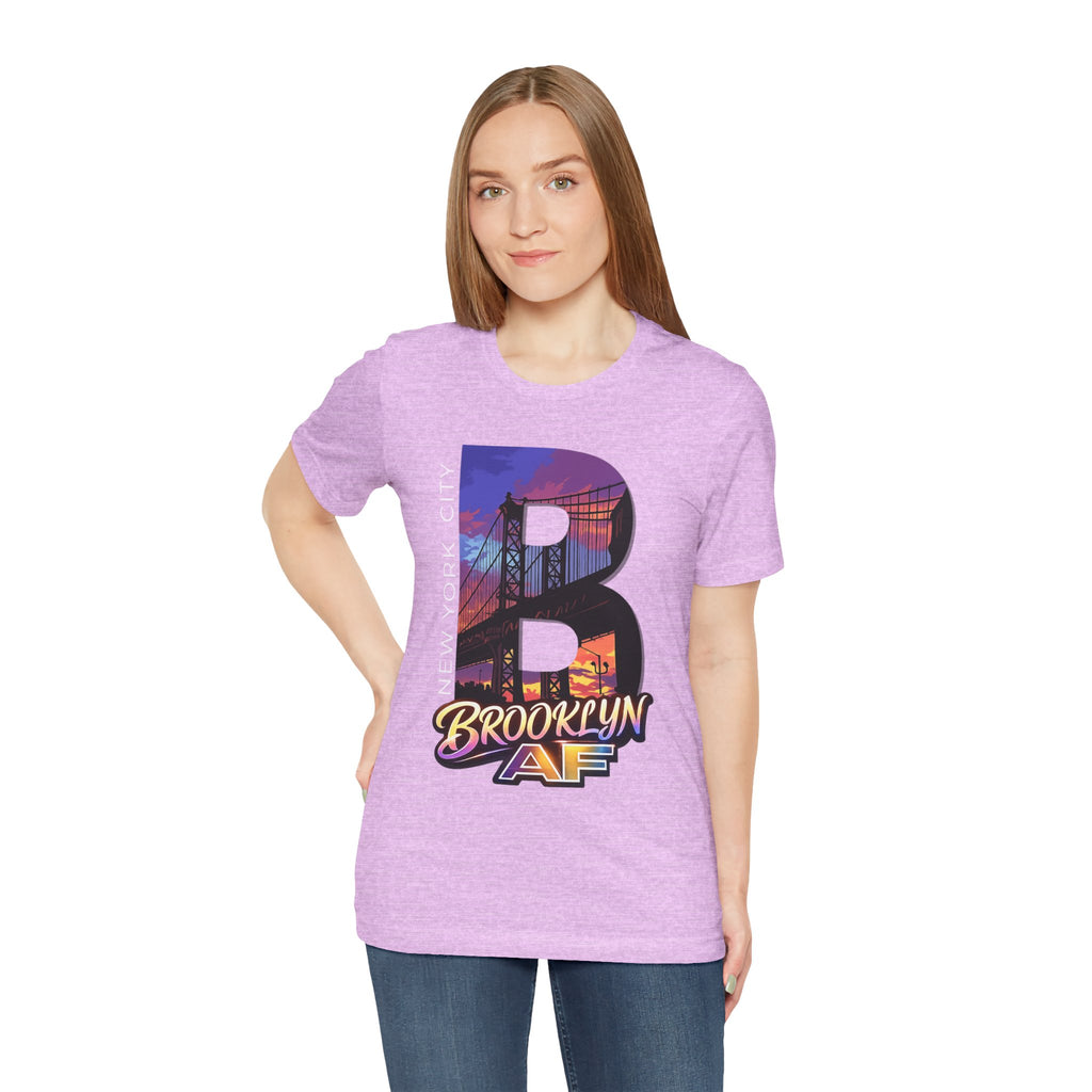 Heather lilac t-shirt worn by a model, front view showing the 'B' Brooklyn Bridge sunset skyline graphic and logo
