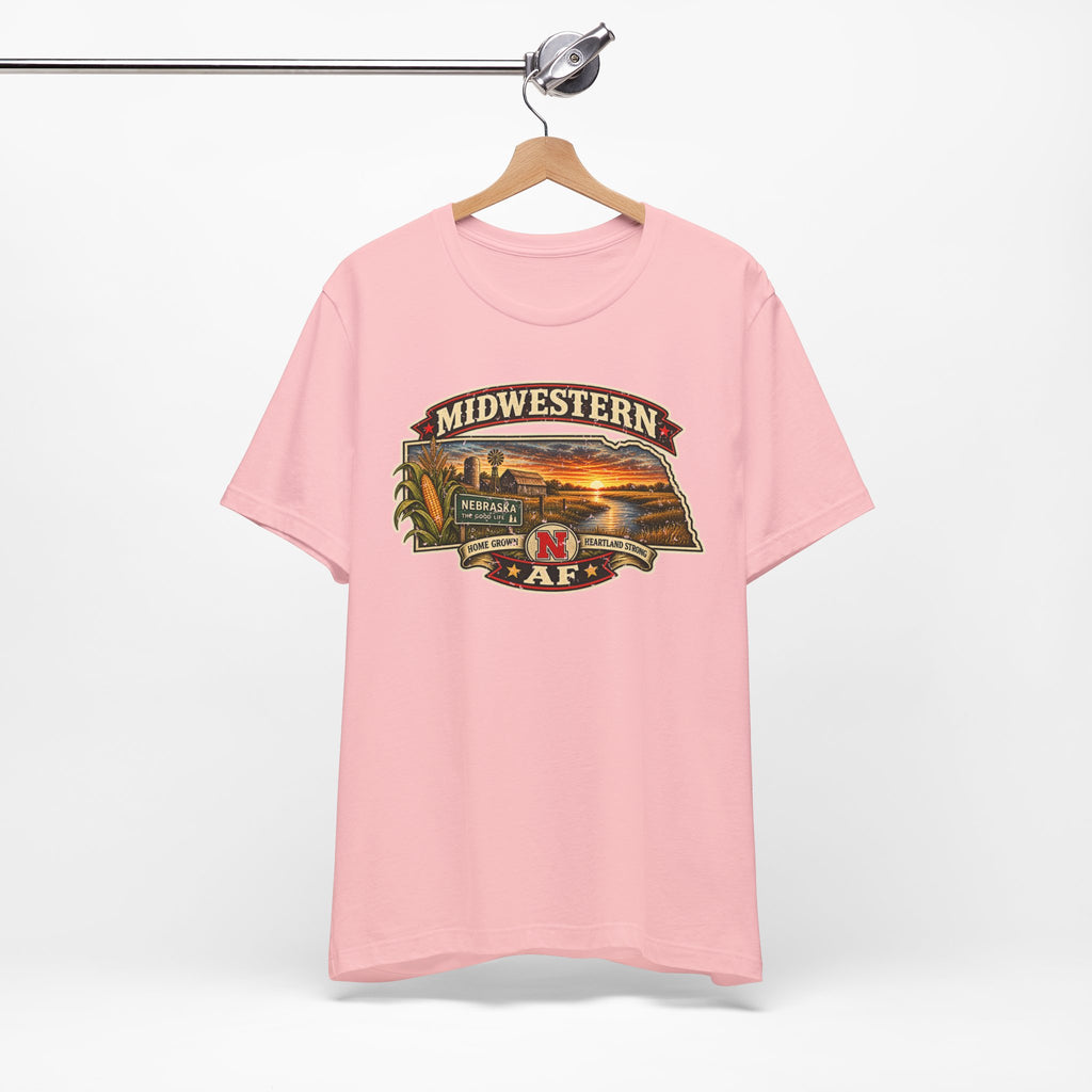 Pink Nebraska tee hanging on a wooden hanger with the Cornhusker State front print