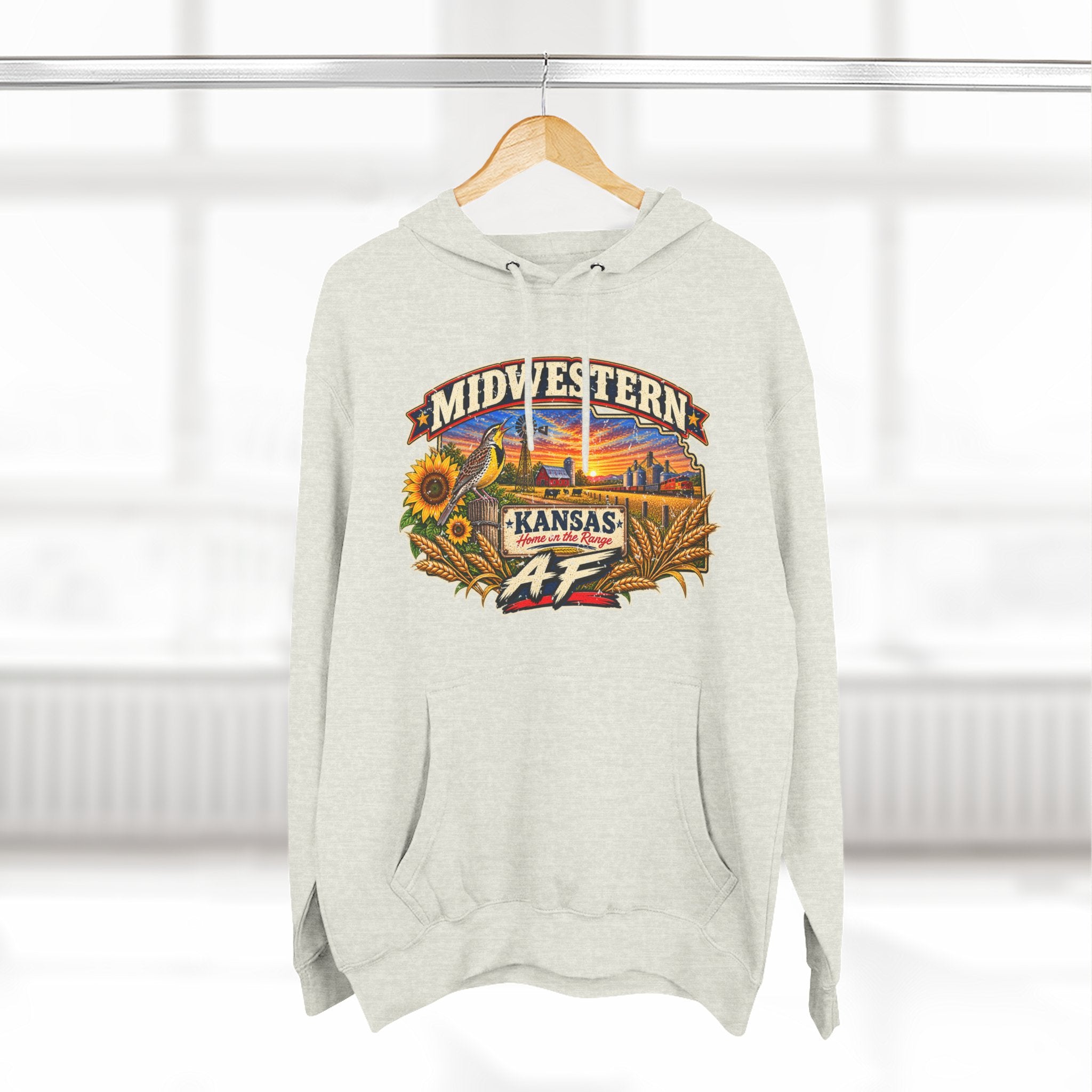 Oatmeal heather Kansas AF hoodie hanging by a window, front print on show