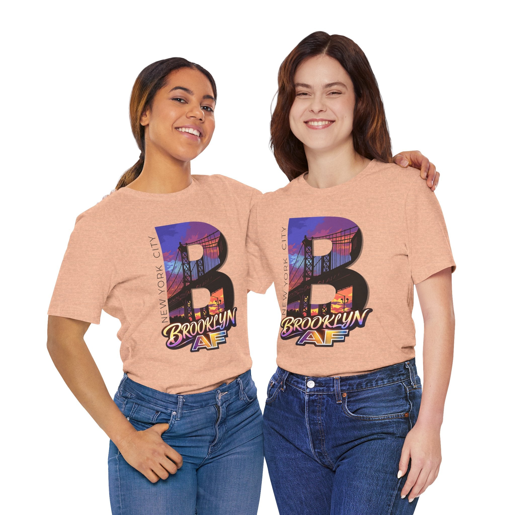 Two models in Heather Peach tees, front view, wearing the oversized "B" Brooklyn Bridge sunset skyline graphic.