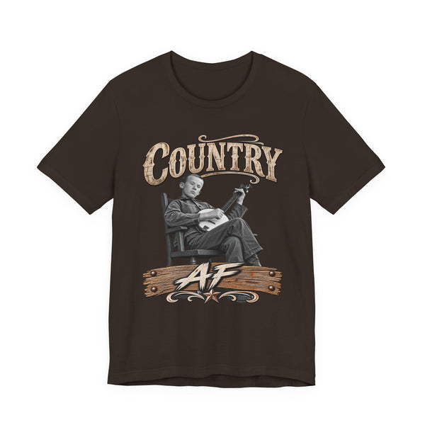Brown Country AF tee laid flat, banjo player in a rocking chair above a wooden AF sign