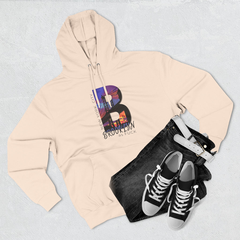 Oatmeal heather hoodie, flat lay styled with jeans and sneakers, featuring the graffiti-style 'Brooklyn as Fuck' text logo.