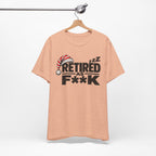 Heather Peach Retired As F**K tee on a wooden hanger against a plain wall