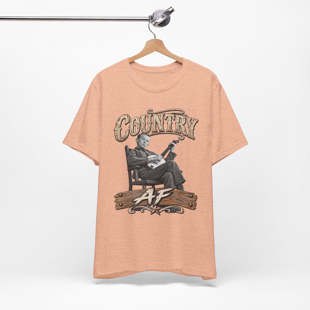 Heather Peach Country AF tee on a wooden hanger against a white wall