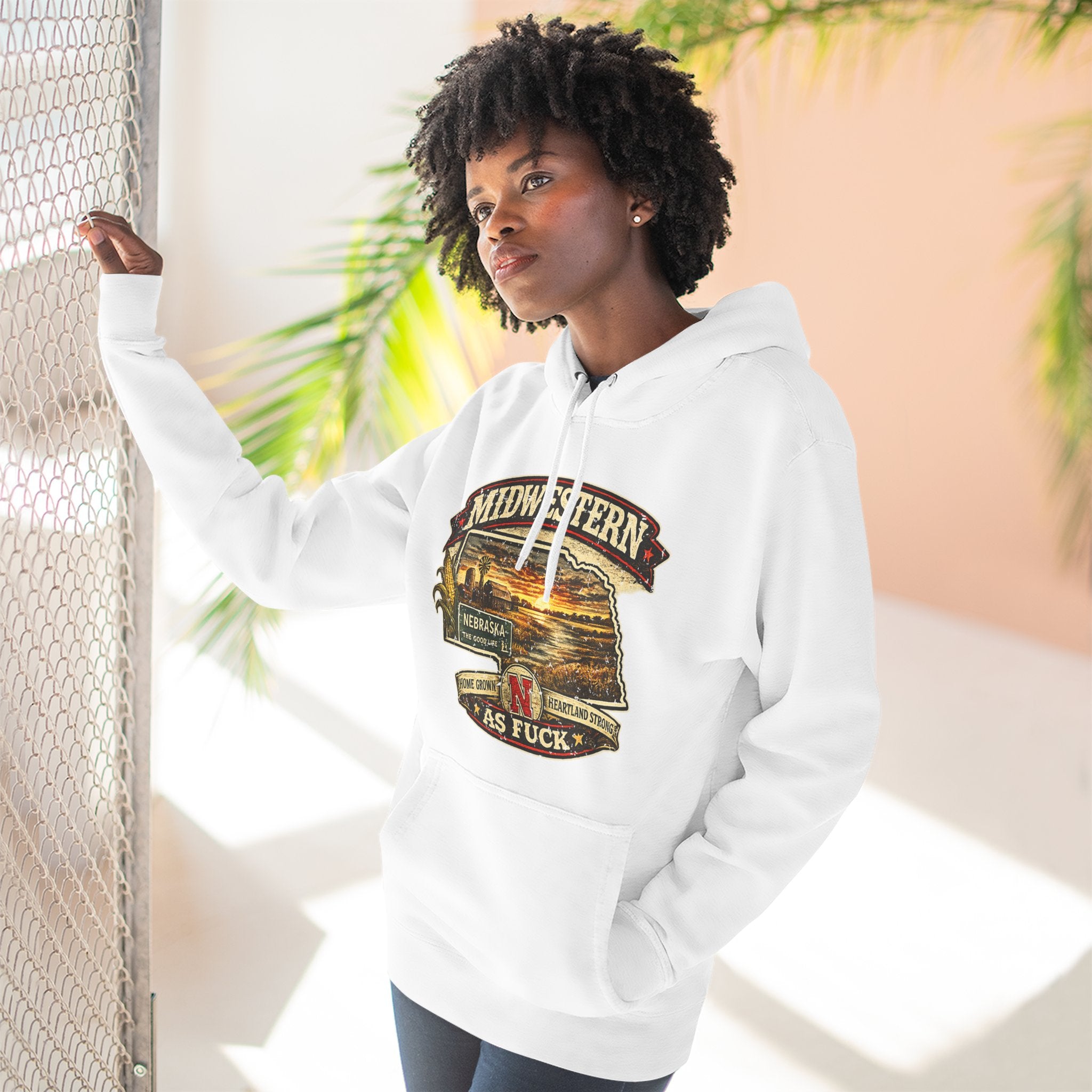 Woman wearing the white Nebraska As Fuck hoodie outdoors in warm afternoon light