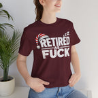 Woman wearing the Maroon Retired As Fuck tee indoors beside a potted palm