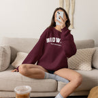 Woman on a sofa in the Maroon custom Midwest sweatshirt