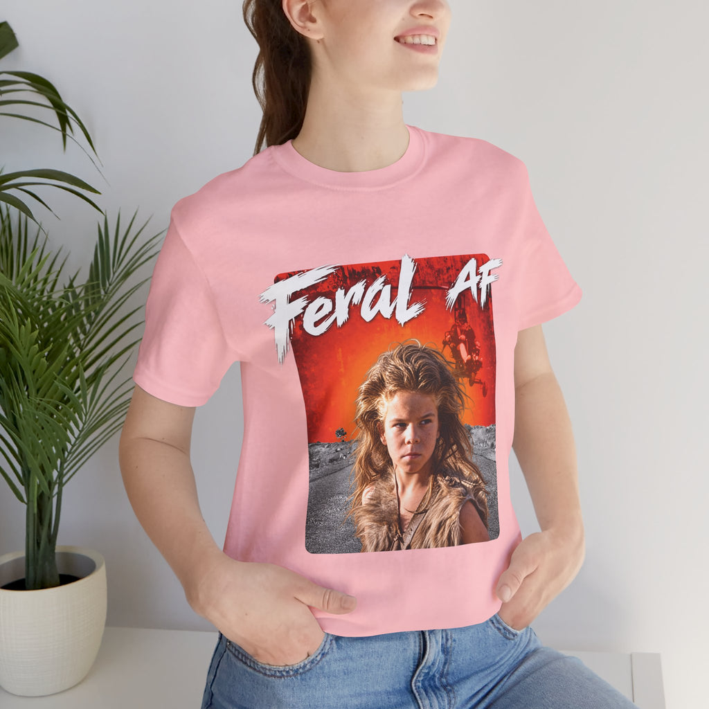 Woman wearing the Pink Feral AF T-shirt indoors, the red-orange wasteland print on her chest