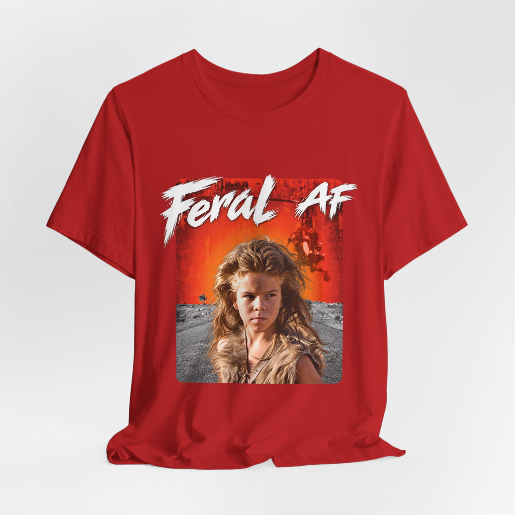 Red Feral AF tee laid out on a pale studio backdrop, showing the sunset wasteland graphic up close