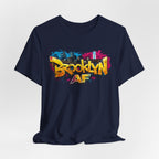 Navy t-shirt, front view flat lay, with graffiti-style Brooklyn AF lettering over a skyline paint-splash design.