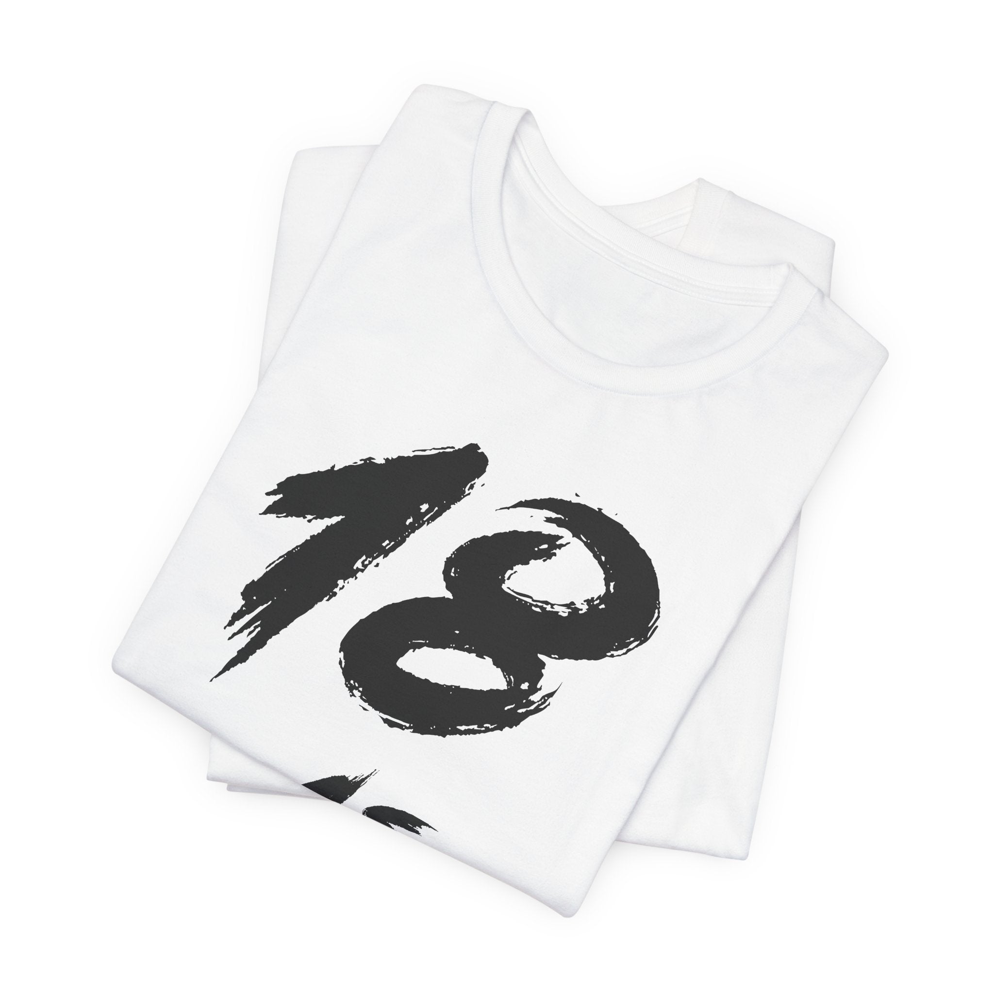 Folded white birthday tees stacked, the black 18 showing on the top fold