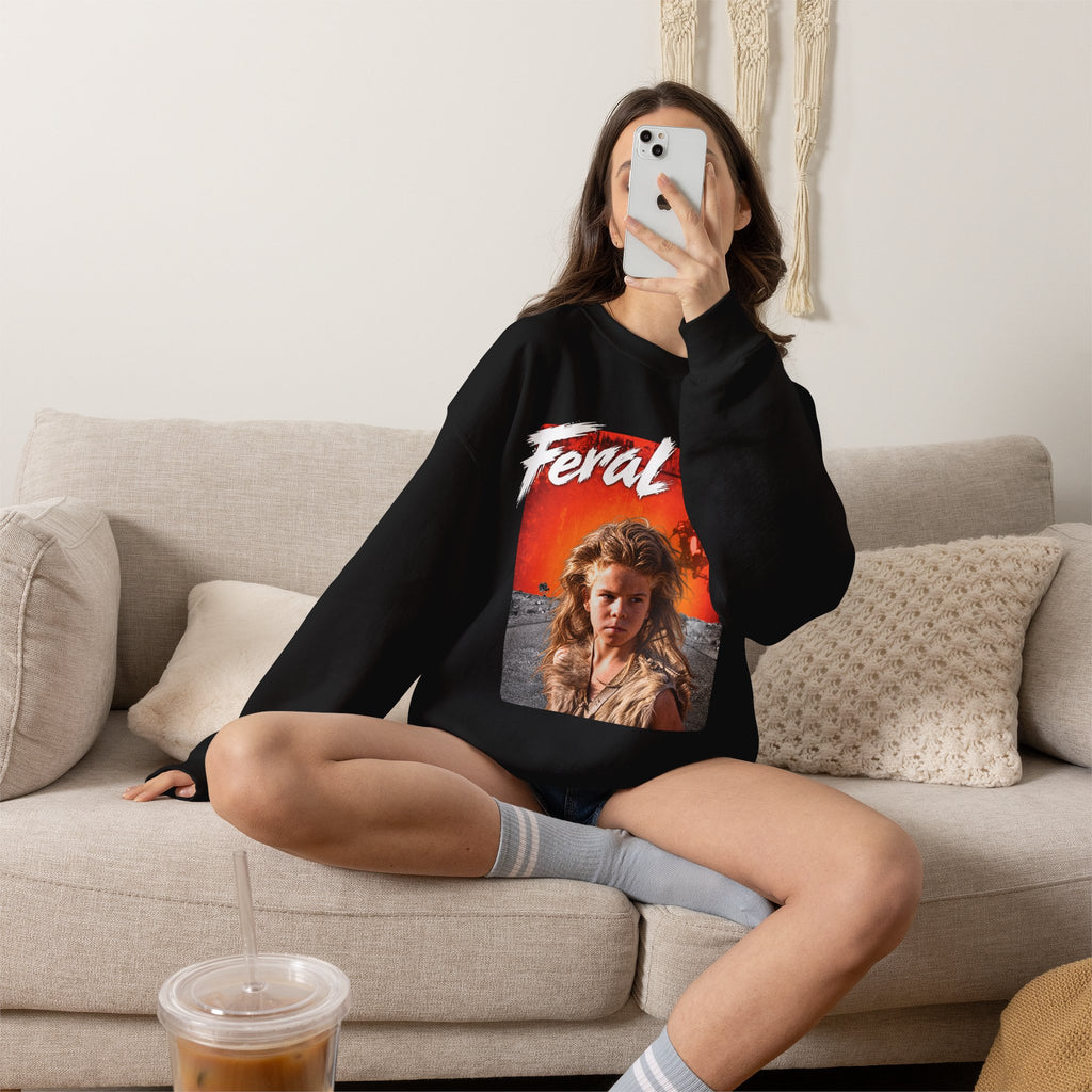 Woman sitting on a sofa in the Black Feral AF sweatshirt, front print facing the camera