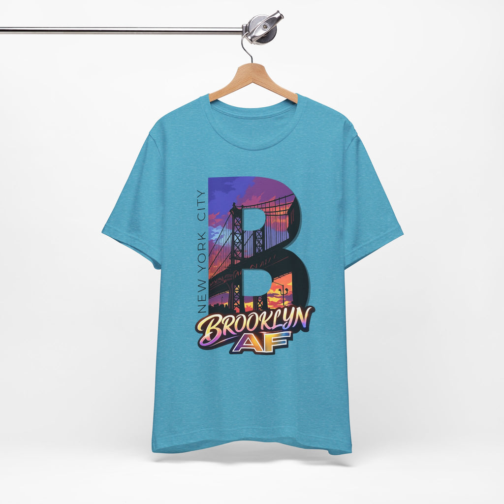 Heather Aqua tee on a hanger, front view, showing the oversized "B" Brooklyn Bridge sunset skyline graphic.