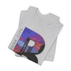 Folded stack of White tees, close-up of the "B" Brooklyn Bridge sunset skyline graphic and "New York City" lettering.