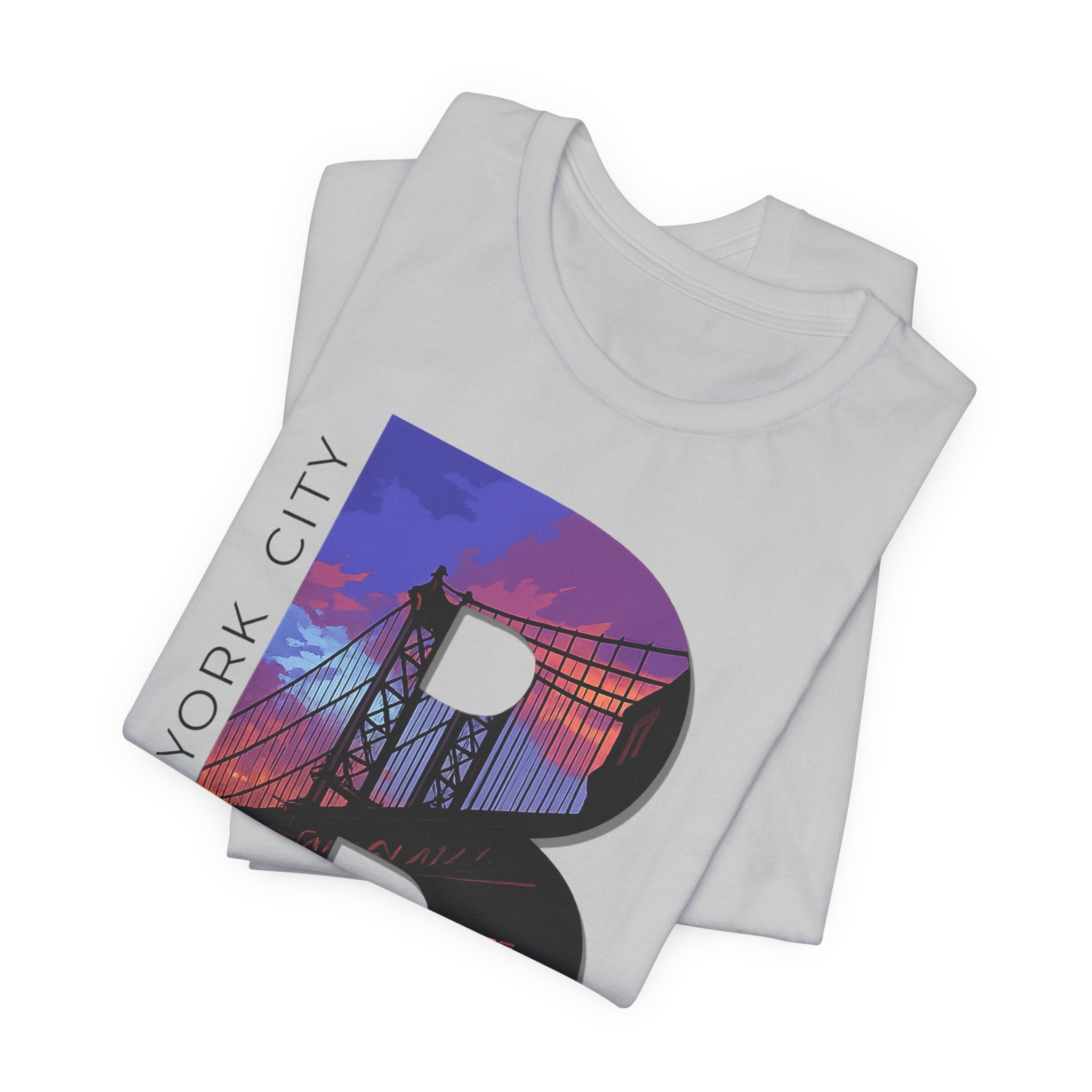 Folded stack of White tees, close-up of the "B" Brooklyn Bridge sunset skyline graphic and "New York City" lettering.