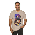 Sand-colored t-shirt worn by a male model, front view, with a bold "B" Brooklyn Bridge sunset skyline graphic.