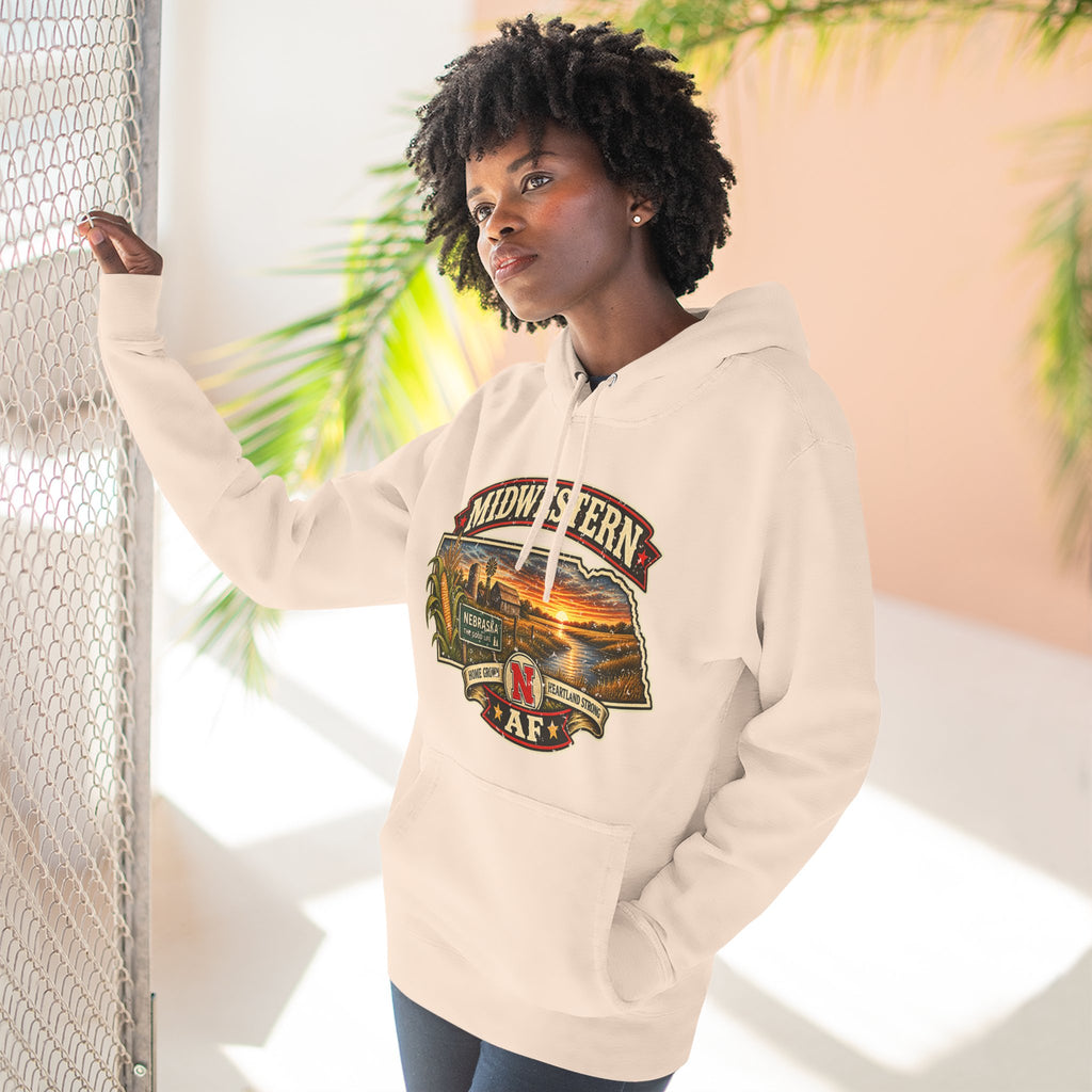 Woman wearing the pale pink Nebraska hoodie outdoors, front print in warm afternoon light
