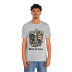 Light gray tee worn by curly-haired male model, Uncle Sam graphic with "I'm American As Fuck, Made In Texas" text