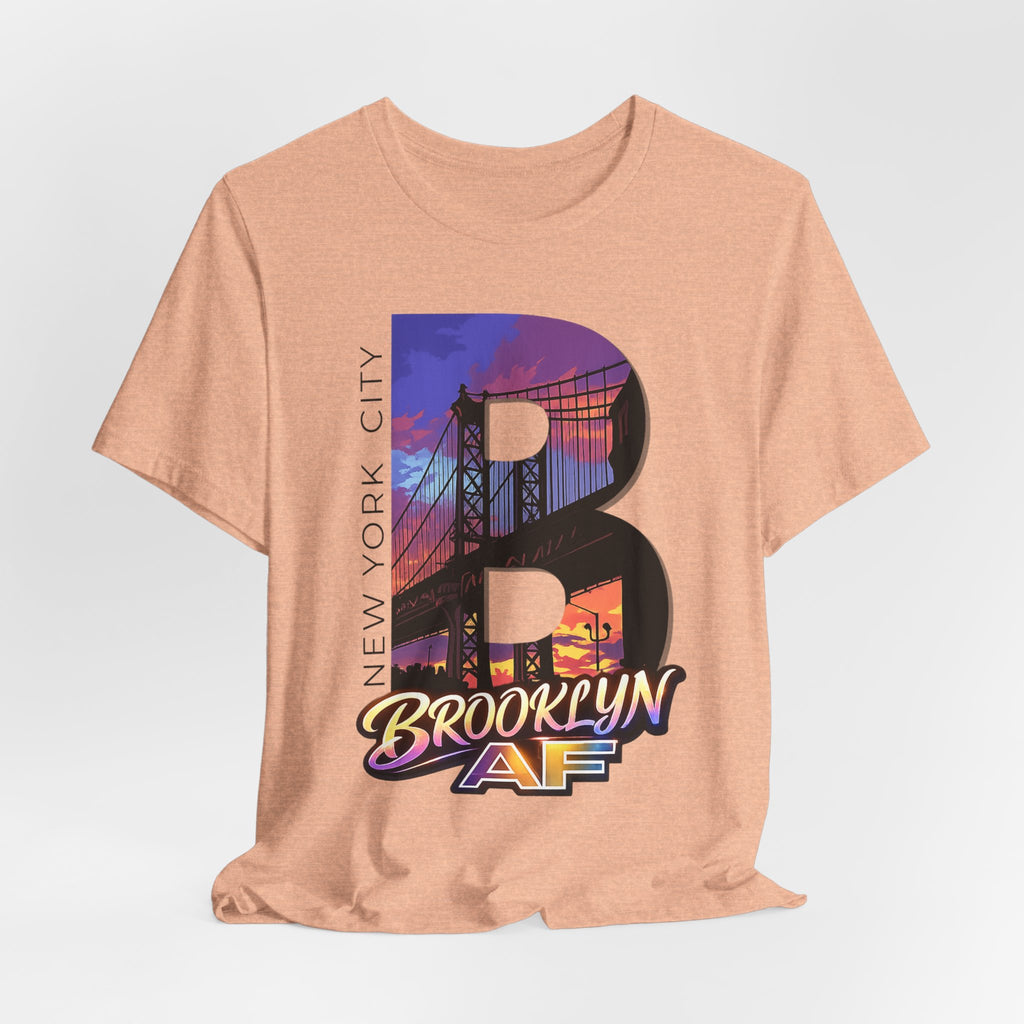 Heather Peach tee on a mannequin torso, front view, showing the "B" Brooklyn Bridge sunset skyline graphic and logo.